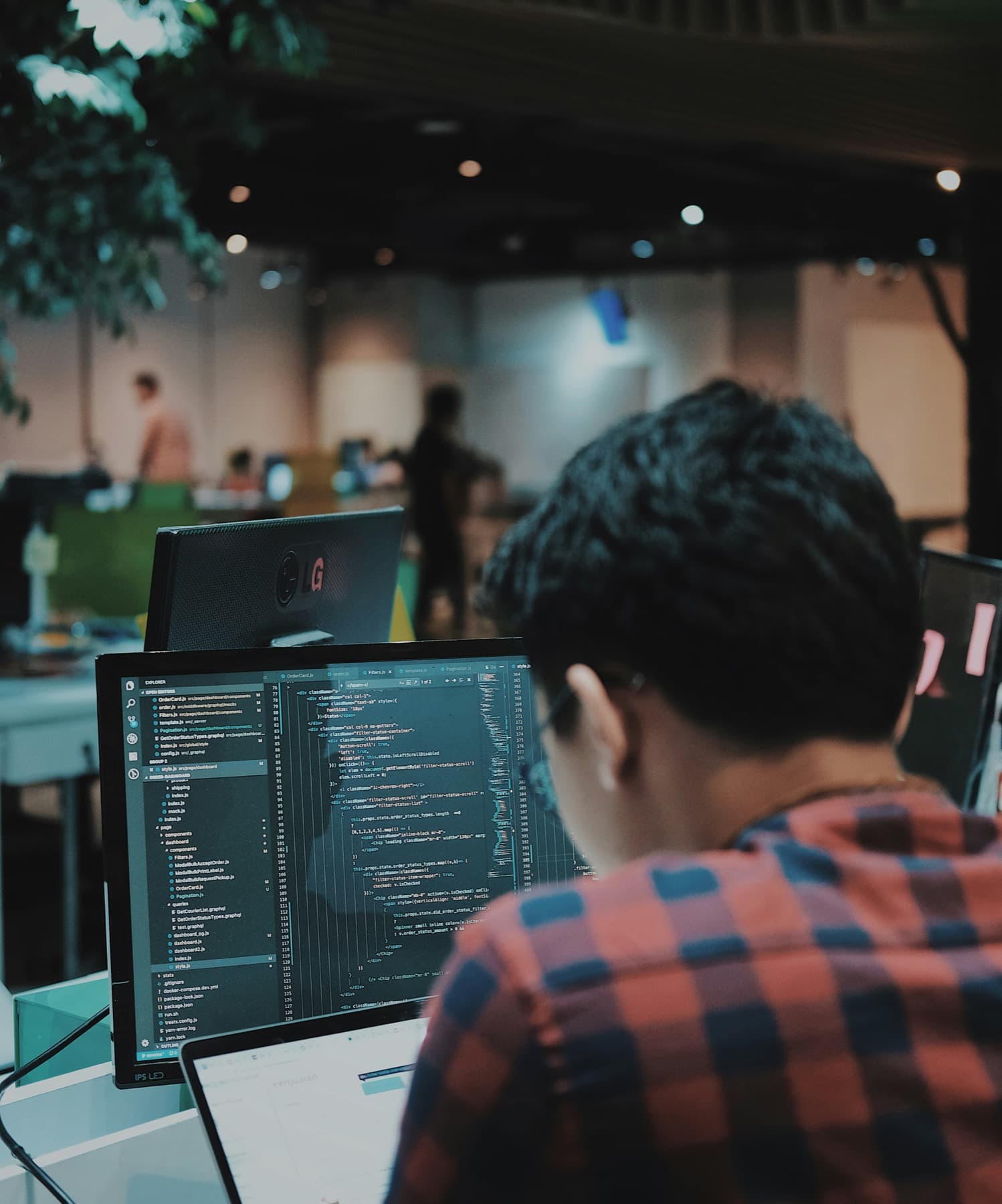 A software engineer working at a laptop in a focused workspace