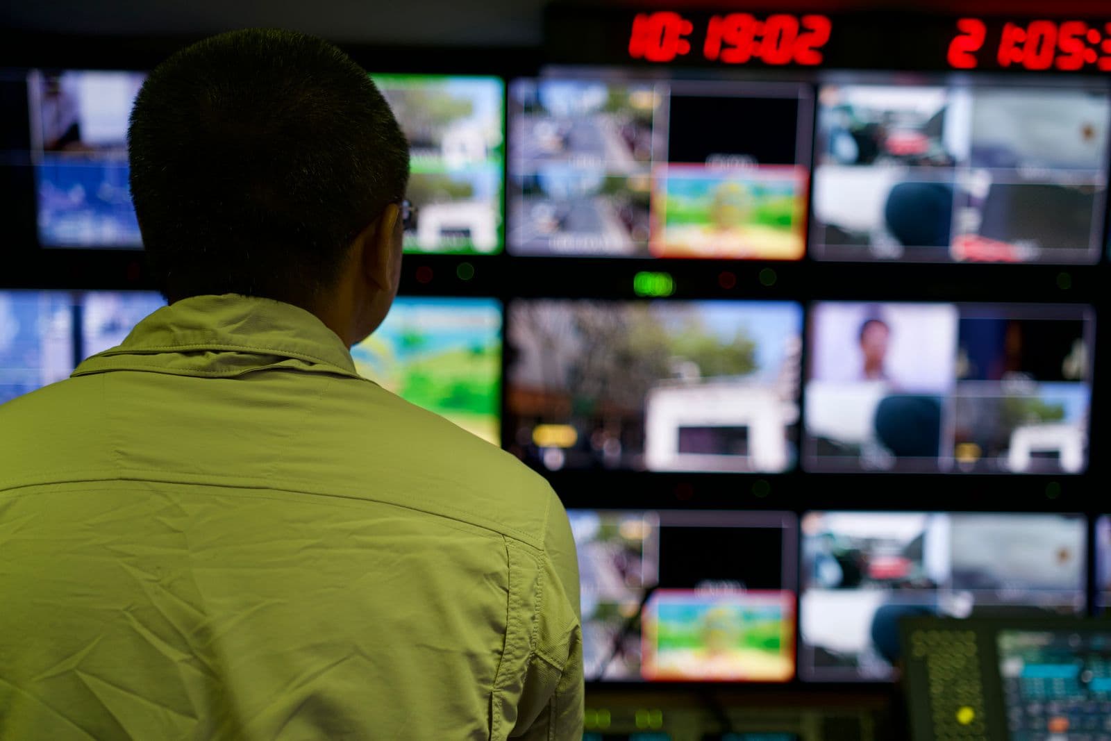 A security operations analyst monitoring multiple screens in a control room