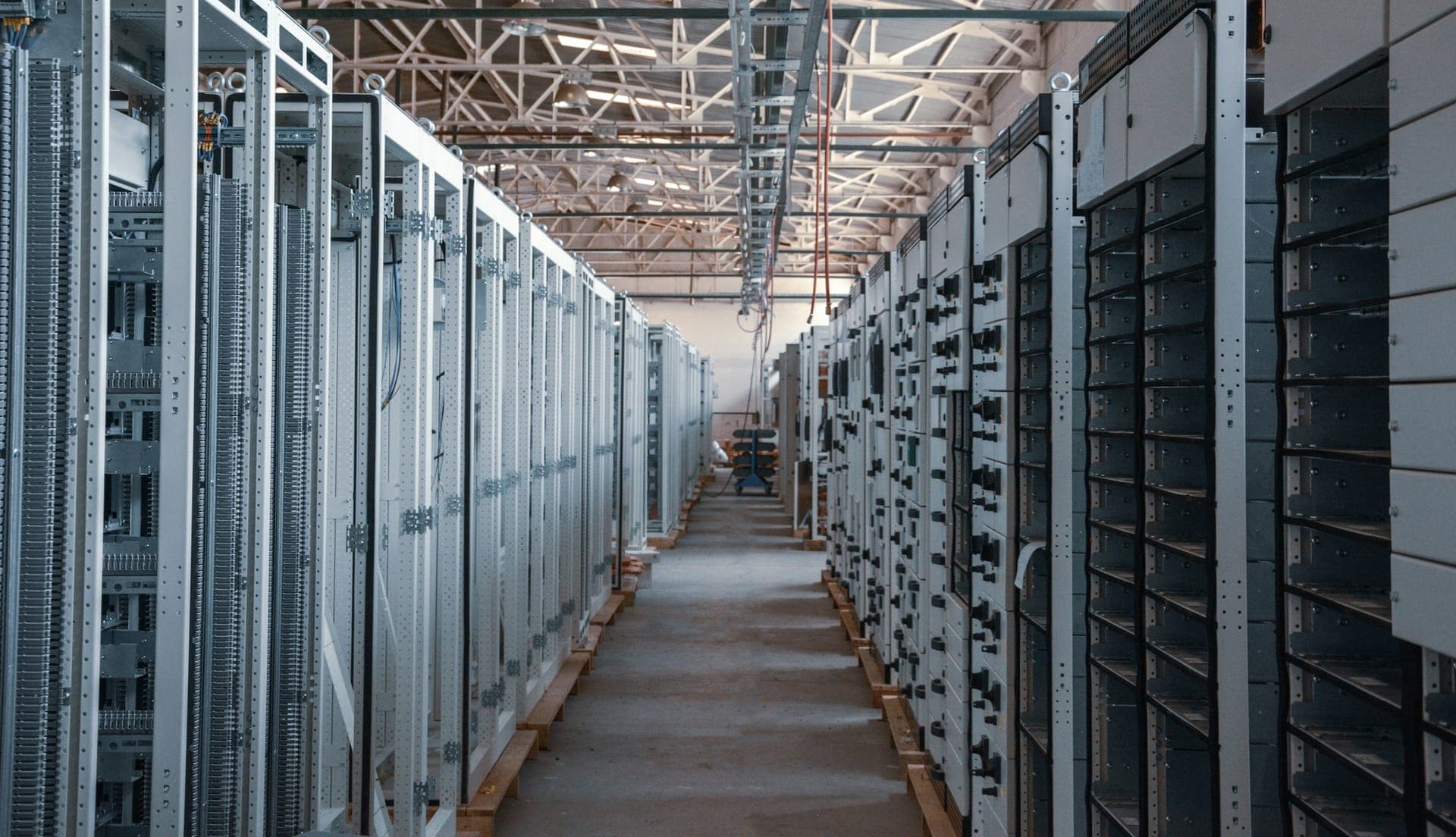 Server-room aisle lined with network and electrical equipment cabinets