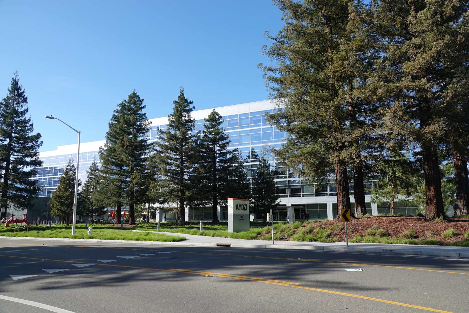 AMD headquarters in Santa Clara, California, with the AMD sign outside the glass-fronted office building.