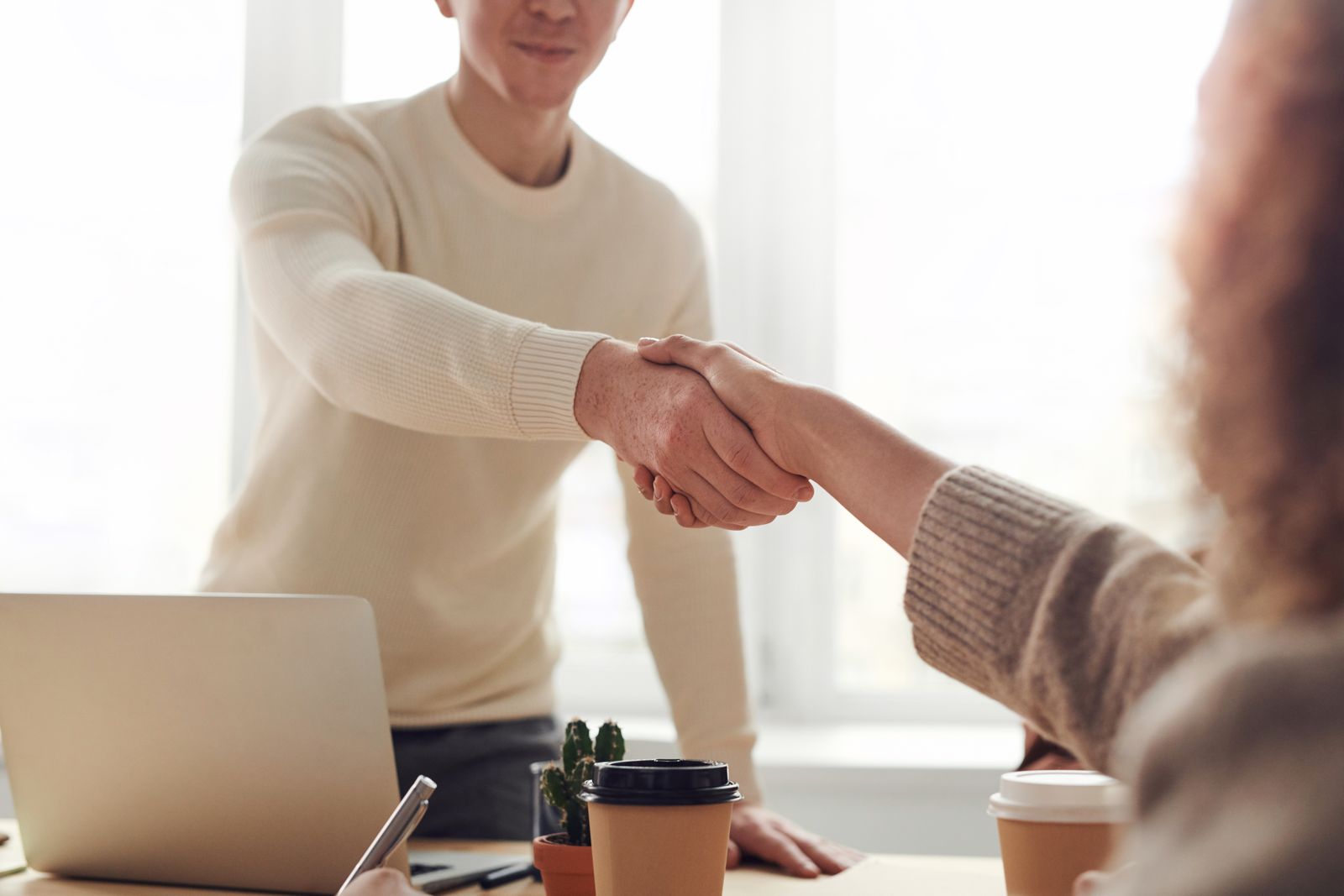 A candidate and interviewer shaking hands after a technical interview, representing Snowflake's hiring loop.