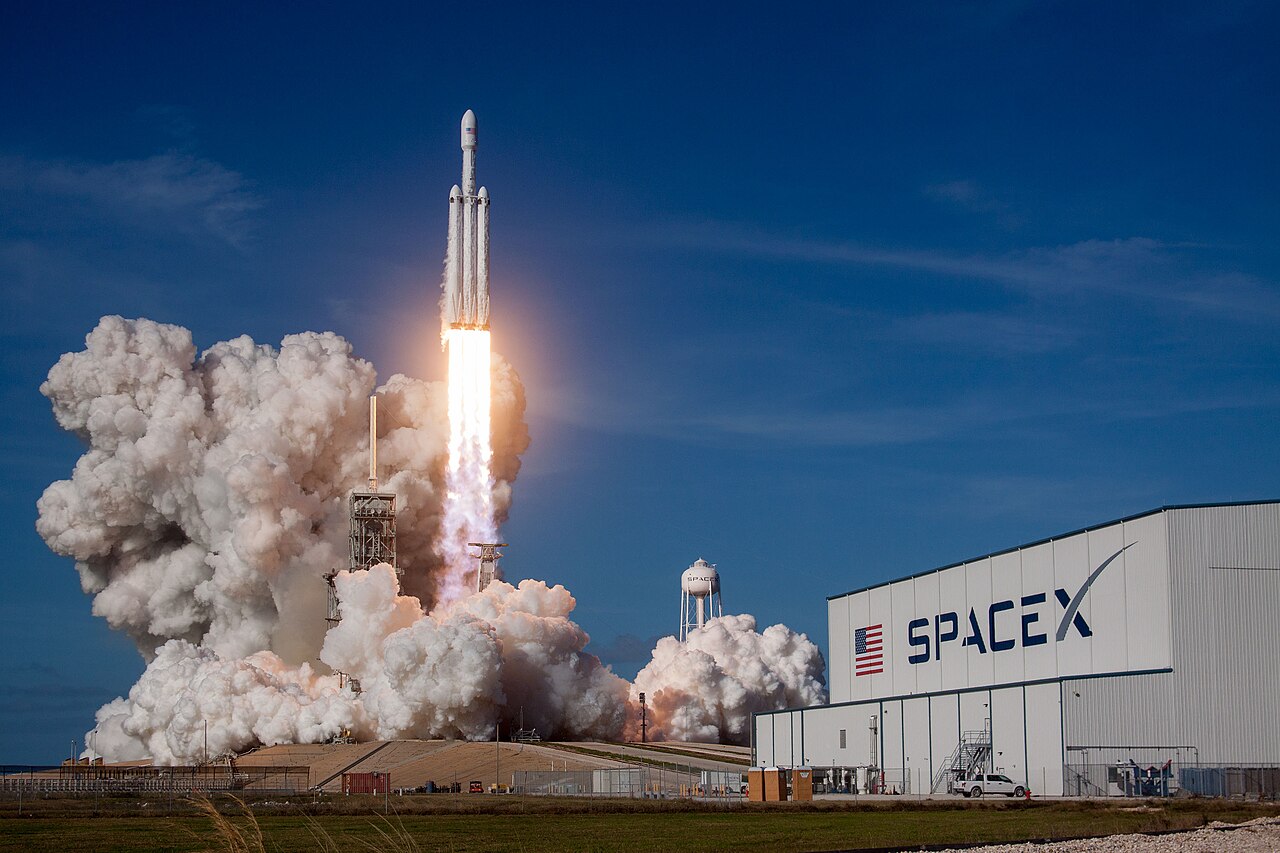 A SpaceX Falcon Heavy rocket lifting off, representing the company's flagship heavy-lift program and the operational scale behind its 2026 IPO.