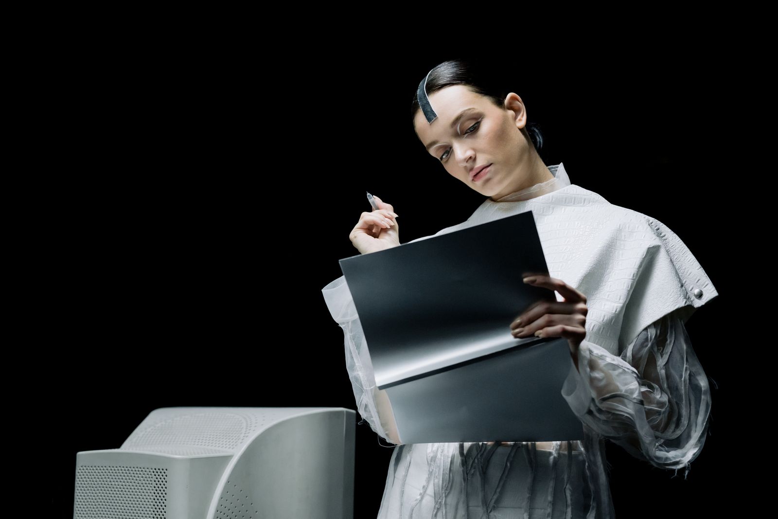 A woman holding a pen while reviewing a folder, representing the human review step that keeps AI-assisted job applications accurate before submission.