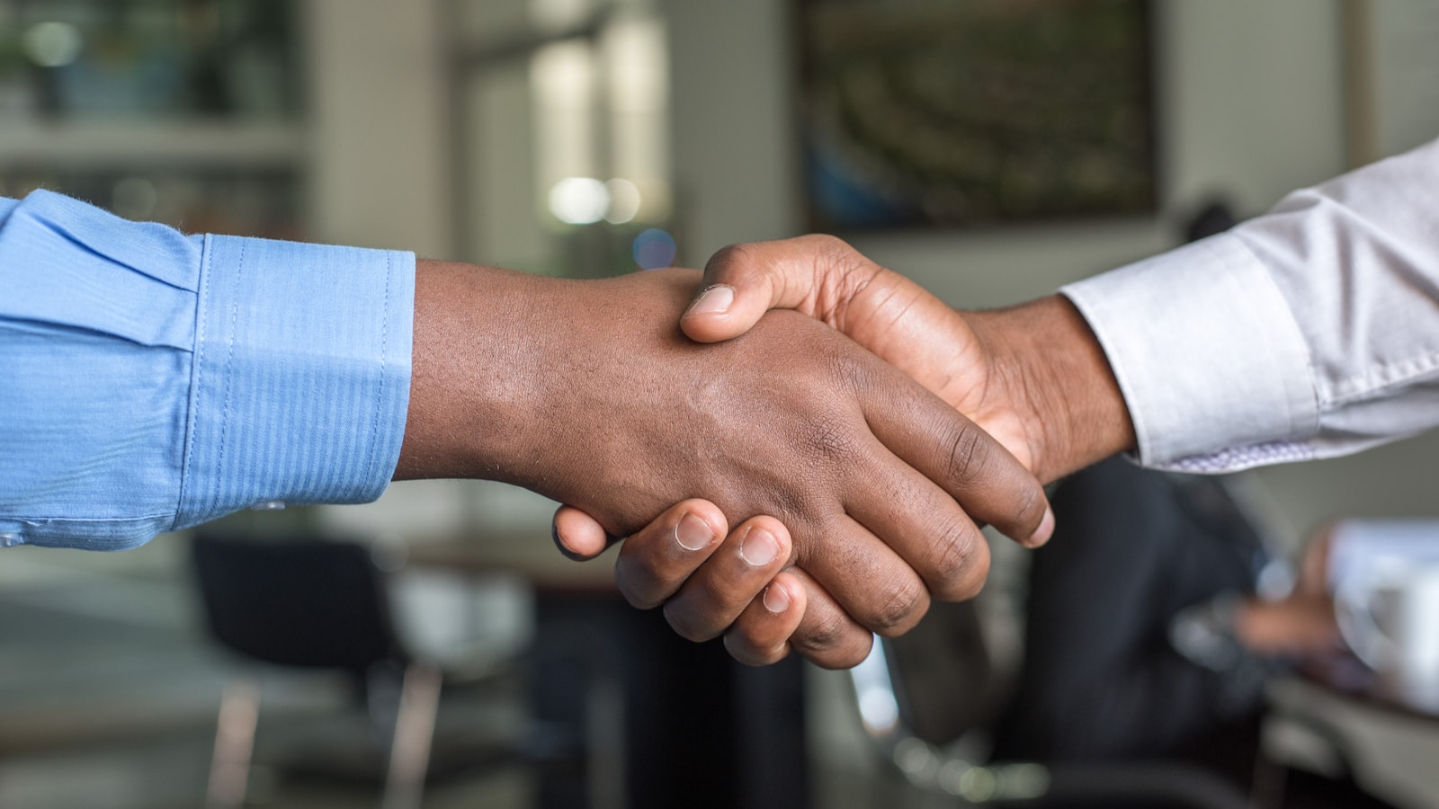 Two people shaking hands after a professional interview conversation, representing the final impression candidates leave after answering common interview questions well.