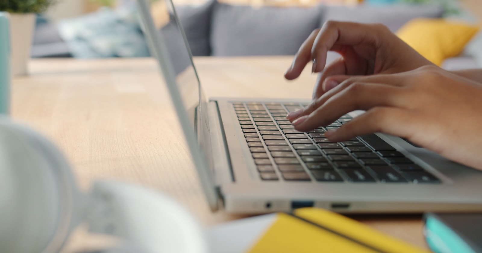A close-up of a person's hands typing a thoughtful follow-up email on a laptop in a calm office environment, representing the careful editing that turns a generic note into a specific one.