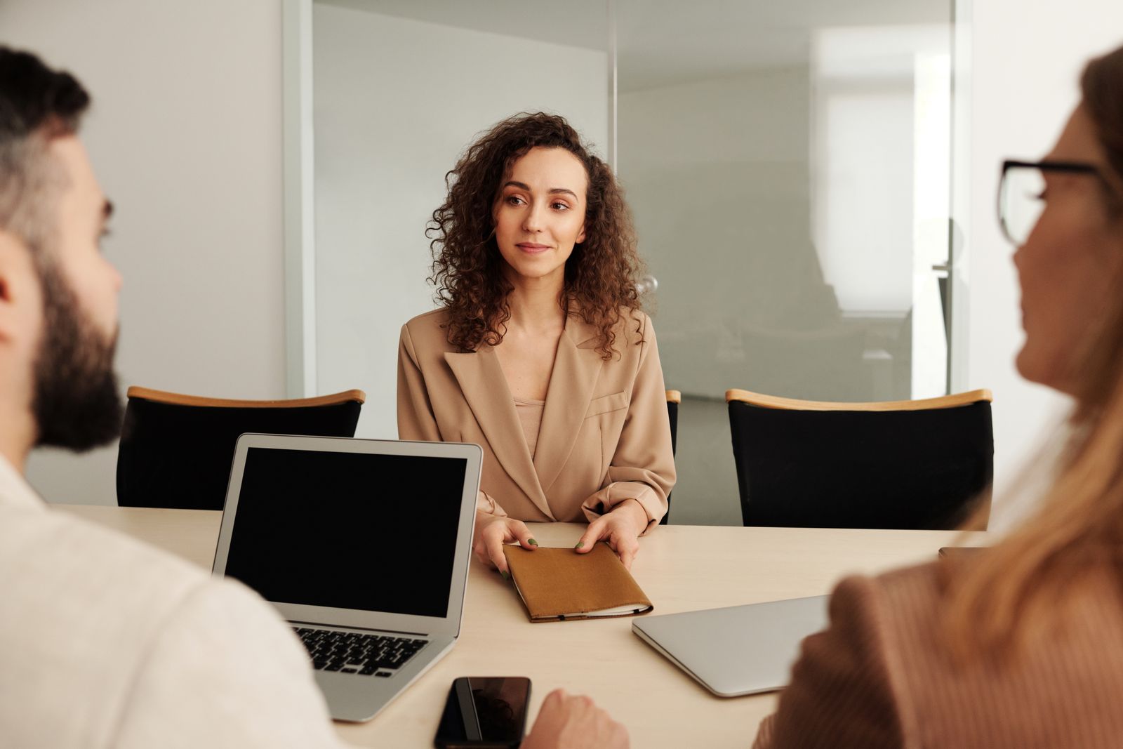 A candidate answering questions during an in-person interview with two interviewers, representing common interview preparation mistakes and how to avoid them.