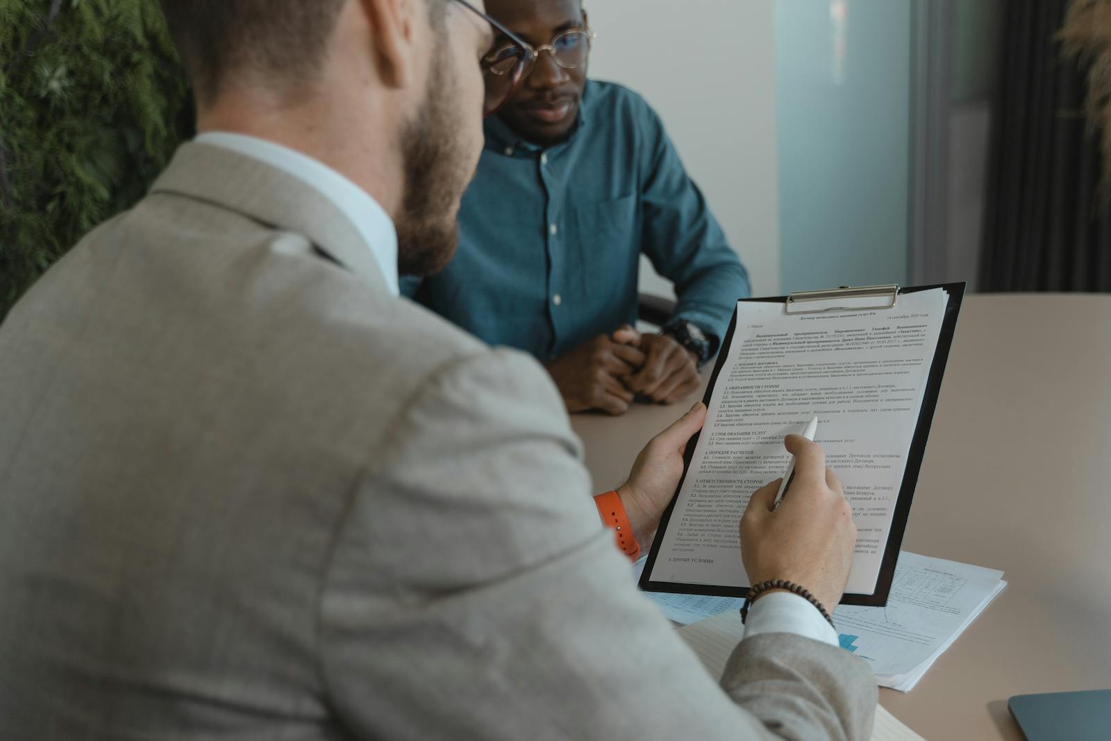 A recruiter reviews a candidate's documents during a job interview in a modern office