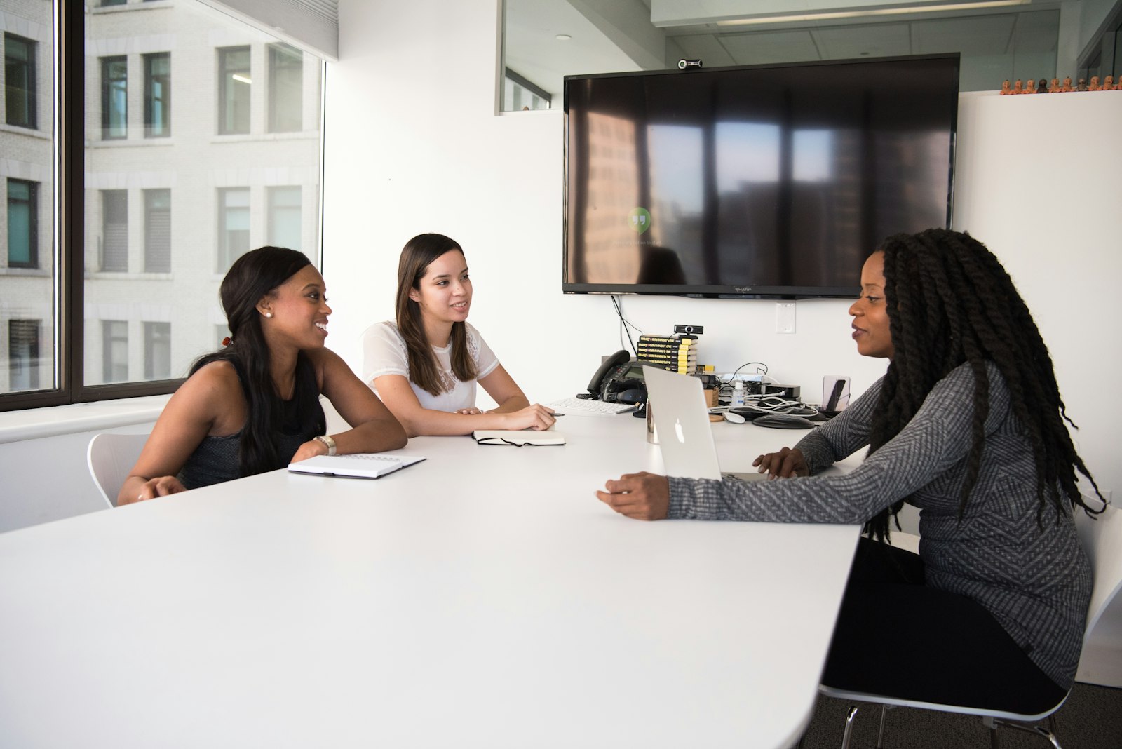 A small hiring team reviews candidates together at a conference table
