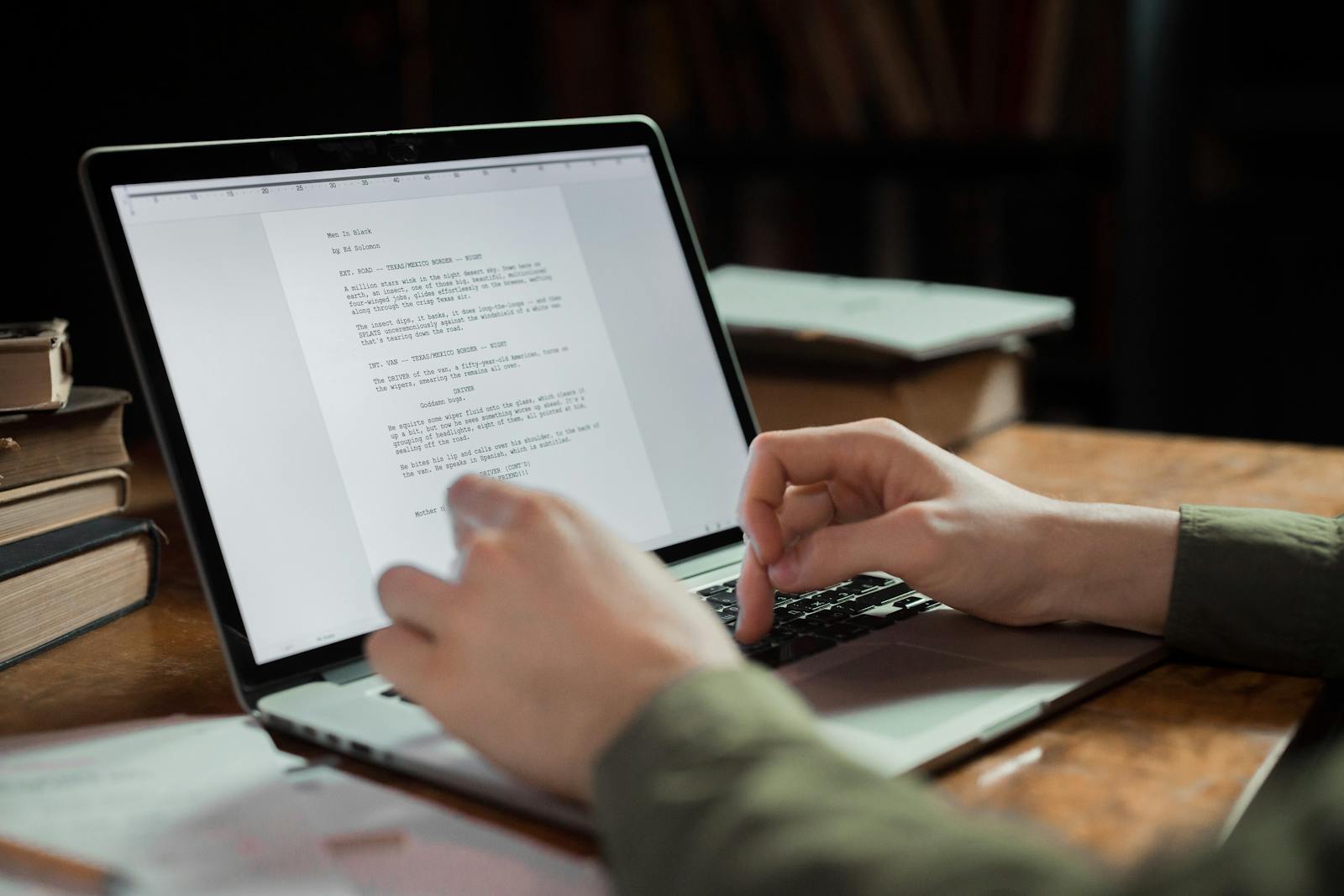 A person typing on a laptop in a quiet workspace, representing the focused work of drafting a simple first resume.