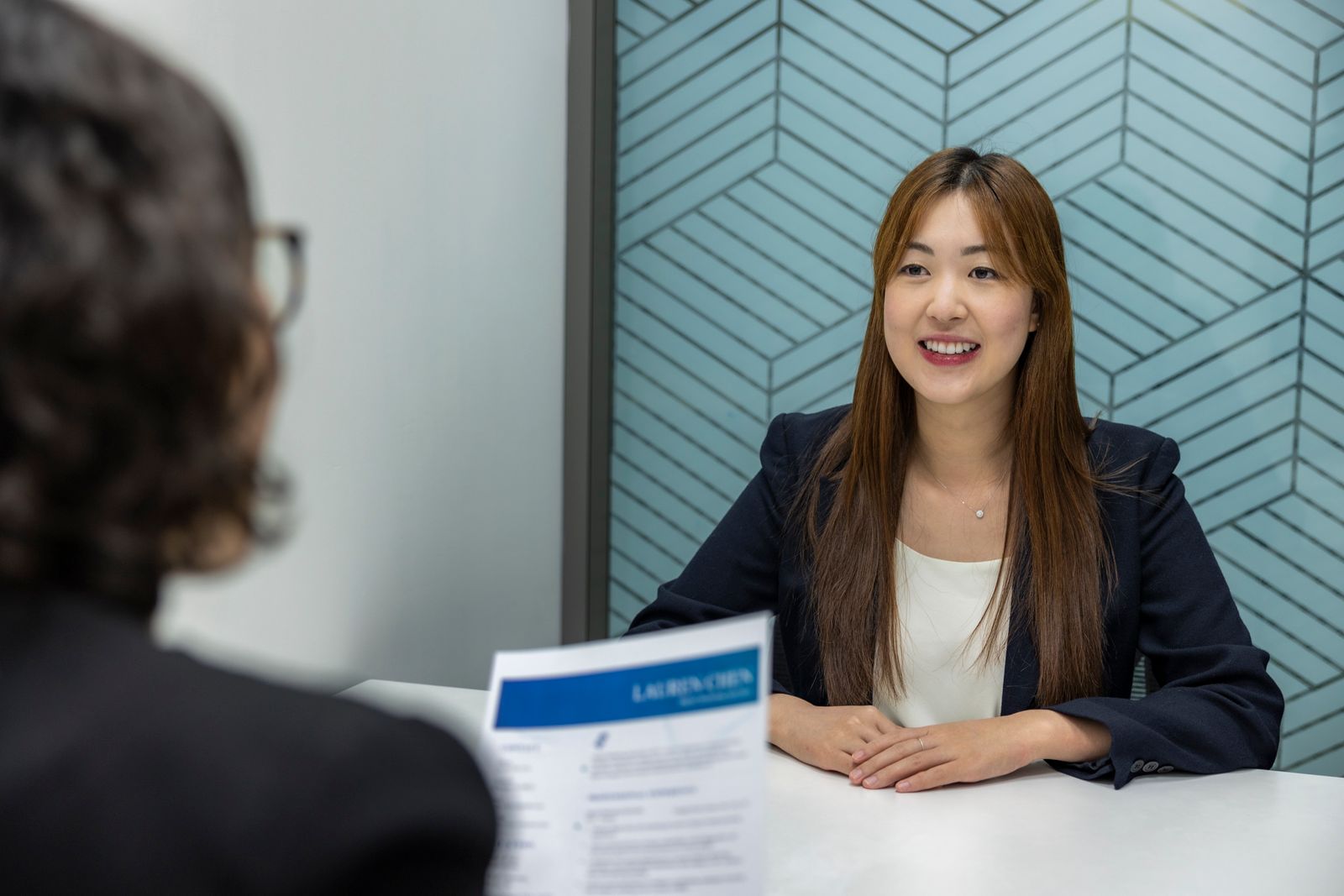 A confident candidate discussing a resume during a job interview, representing the human review stage that follows ATS parsing and keyword matching.